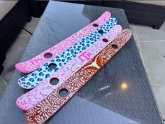 three different colored skateboards sitting on top of a glass table next to each other