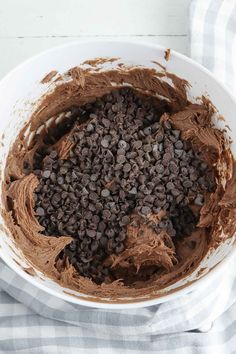 a white bowl filled with chocolate frosting on top of a checkered table cloth