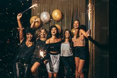 group of young women celebrating with confetti and sparklers