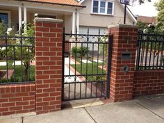 an iron gate in front of a brick house