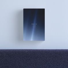 a book sitting on top of a blue couch next to a white wall and floor