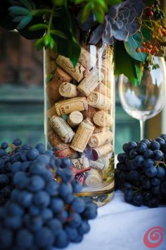 wine corks and grapes in a jar on a table