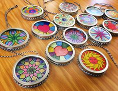 a group of different colored glass ornaments on a wooden table with string attached to them