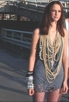 a woman in tights is standing on a skateboard with chains around her neck