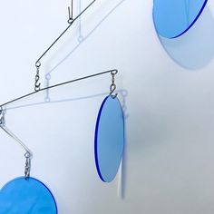 three blue circular objects hanging from hooks on a wall