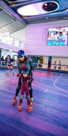 two people riding roller skates in an indoor arena