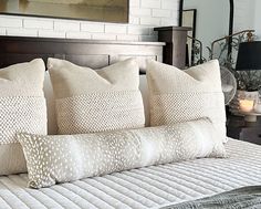 a bed with four pillows on top of it