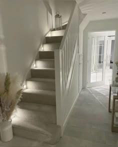 the stairs are lit up with leds in this home entryway, which also has a table and chairs