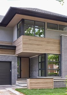 a modern house with two story windows on the second floor