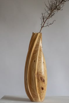 a wooden vase with a branch sticking out of it