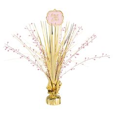 a gold vase filled with pink flowers on top of a table