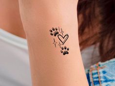 a woman with a dog paw and heart tattoo on her arm