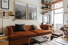 a living room filled with furniture and pictures on the wall next to a coffee table