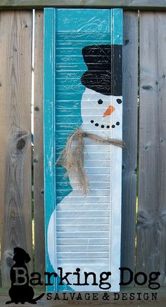 a snowman painted on the side of a blue door with a burlock