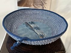 a blue basket with a fork and knife in it sitting on top of a table