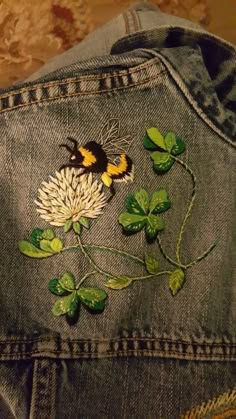 a pair of jeans with embroidered flowers on them