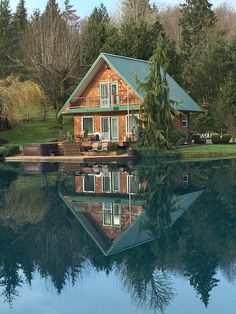 a house sitting on top of a lake surrounded by trees