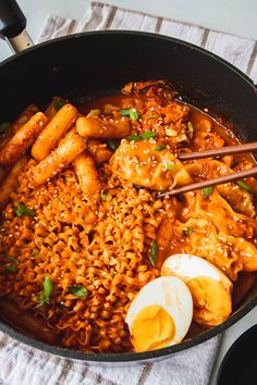 a skillet filled with noodles, eggs and meat