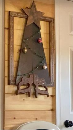 a wooden christmas tree hanging on the wall