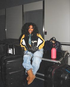 a woman sitting on top of luggage in an airport