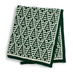 a green and white knitted dishcloth on a white background with an arrow pattern