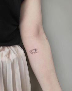 a woman's arm with a small tattoo on the left side of her arm