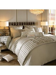 a bed with white comforter and pillows in a room