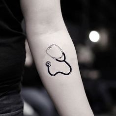 a black and white photo of a stethoscope tattoo on the left arm