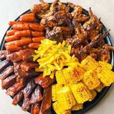 an assortment of meats and corn on the cob are arranged on a plate