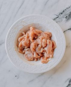 a white bowl filled with food on top of a marble counter