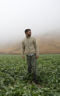 a man standing in the middle of a foggy field