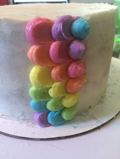 there is a white cake with rainbow icing on the top and bottom layer that looks like gummy bears