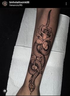 a snake and rose tattoo on the arm