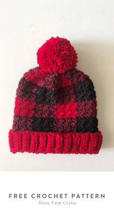 a red and black knitted hat with pom - pom on the top