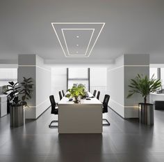 an empty conference room with plants in the middle