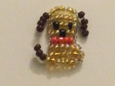 a beaded dog brooch sitting on top of a table