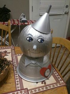 a metal pumpkin sitting on top of a wooden table