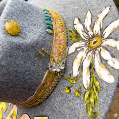 This "Peace Hippie" Hand Painted Hat is a one-of-a-kind work of art. This hat is just FUN!!! It has a hat band and the letters, PEACE created from a piece of an abstract painting on artist canvas. A huge hand painted daisy, lots of vintage golden trim, hand stitched little turquoise beads and a one of a kind hat pin with a cool golden bead!. WB-114Carmen has added a magical dimension to the design, using a wood-burning tool to create the engravings. This hat will come with a signed and dated pai Hat Trimming Ideas, Hand Painted Hats For Women, Painted Apparel, Hand Painted Hats, Burned Hats, Art Hats, Scrap Crafts, Boho Hats, Painting Clothes