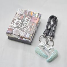 a pair of sneakers keychains sitting next to a book