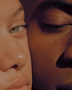 a close up of a man and woman's face with their eyes closed to each other