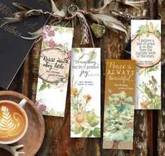 three bookmarks with flowers on them next to a cup of cappuccino