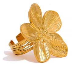 This ring showcases delicate floral details that add a touch of nature-inspired beauty to your look. The PVD gold plating ensures a lasting, lustrous finish, making it a timeless accessory for both casual and formal occasions. The ring size is adjustable for your convenience! 🎁 Perfect for gifting - let me know if it's a gift to someone special and I will add a cute velvet pouch to your order for free! ✨ Stainless Steel with PVD gold plating (4 microns) ✨ Ring size 7 and resizable ✨ Featuring big flower ✨ Elegant and luxurious accessory Gold Flower Ring, Steel Flowers, Gold Color Ring, Stainless Steel Accessories, Trendy Fashion Jewelry, Ringe Gold, Charm Rings, Big Flowers, Jewelry Stand