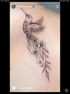 the back of a woman's stomach with a hummingbird tattoo on it, and flowers