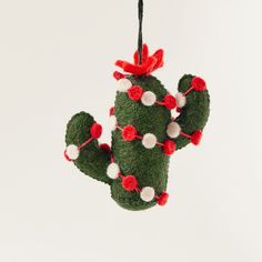 a green cactus ornament with red and white pom - poms on it