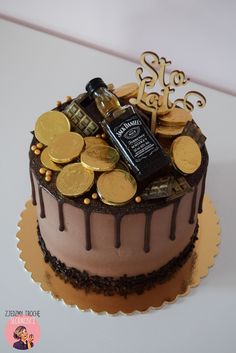 a chocolate cake topped with gold coins and a bottle of wine on top of it