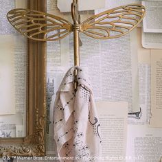 a towel hanging on a rack in front of a wall with old books and an ornate mirror