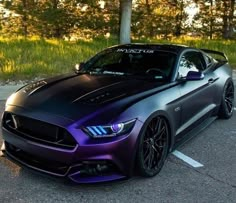 a purple and black mustang parked in a parking lot