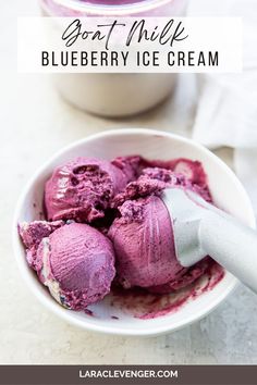 blueberry ice cream in a white bowl with a spoon next to it and the words, best milk blueberry ice cream