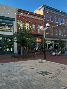 people are walking on the sidewalk in front of shops