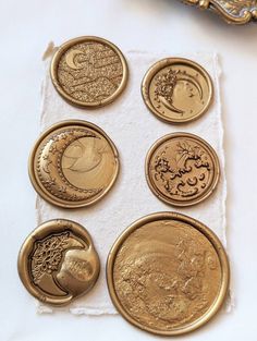 six different types of gold coins on a white cloth with a golden frame in the background